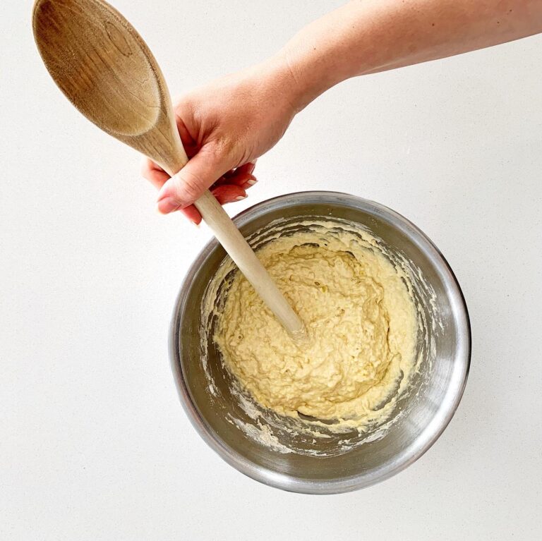 Mixing white pizza dough by hand in a bowl for homemade truffle pizza