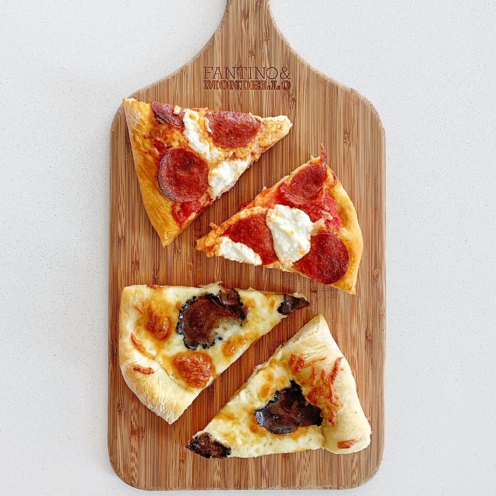 White pizza slices with black truffle carpaccio and pepperoni on a wooden pizza board
