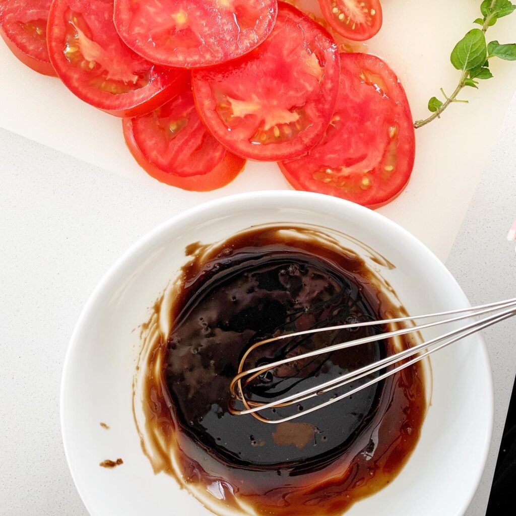Ingredients for balsamic vinaigrette topping: honey, balsamic vinegar, and olive oil measured in bowls.