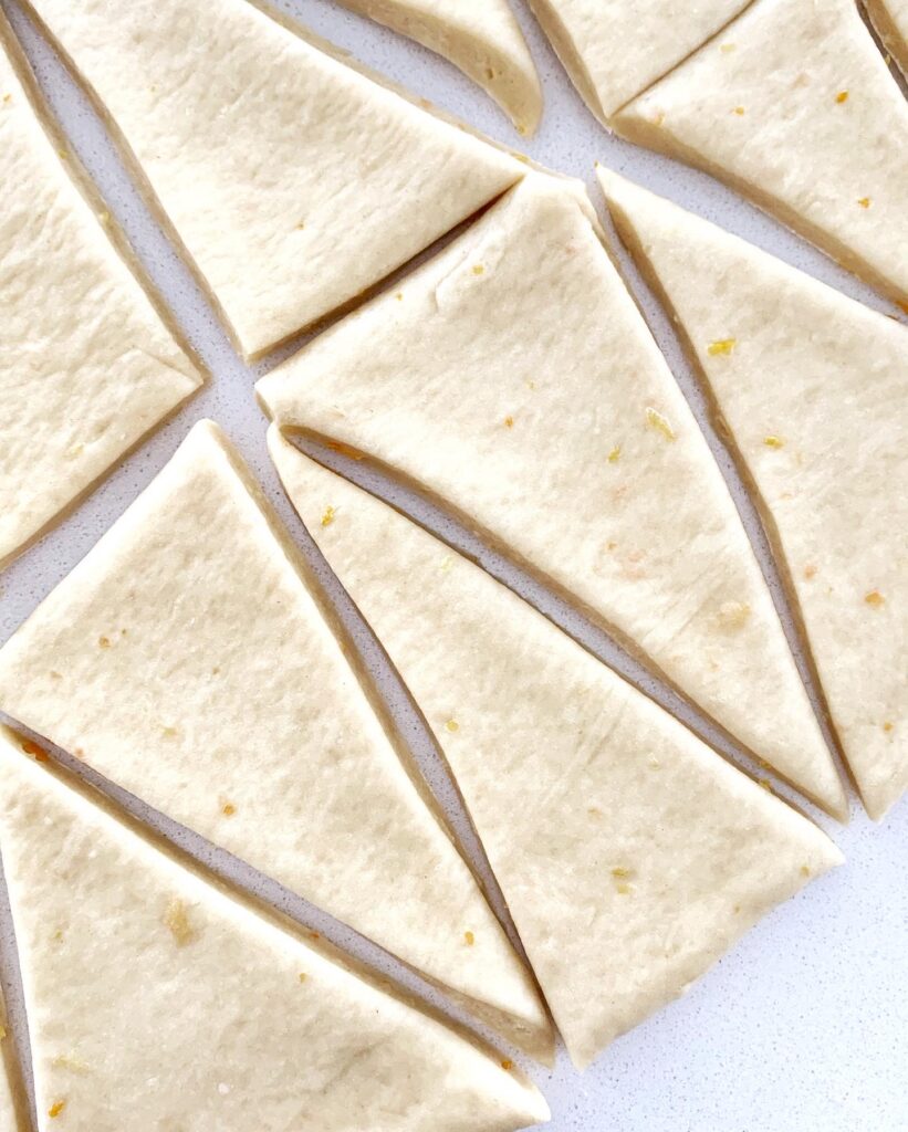 Rolled dough cut into triangles for shaping homemade Italian cornetti.