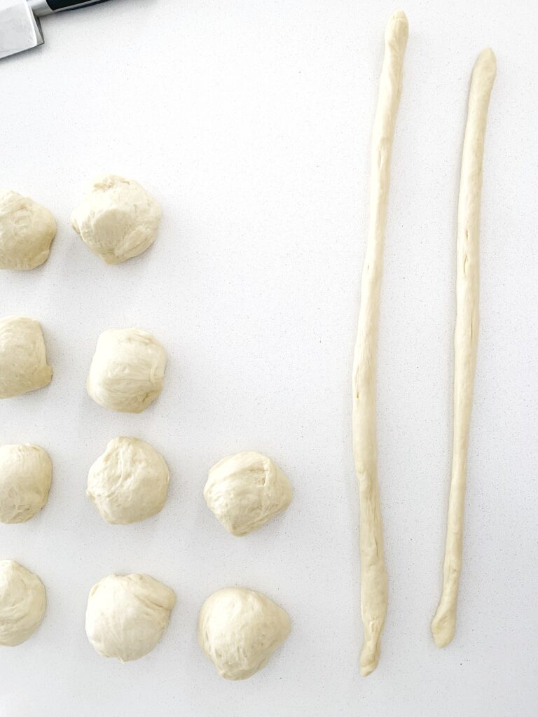 Italian Easter bread dough divided into portions and rolled into long strands for pane di Pasqua.