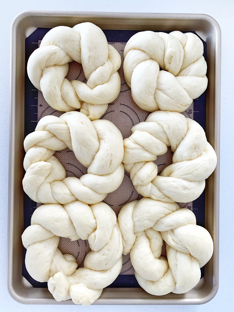 Unbaked pane di Pasqua dough rings arranged on a baking sheet before rising