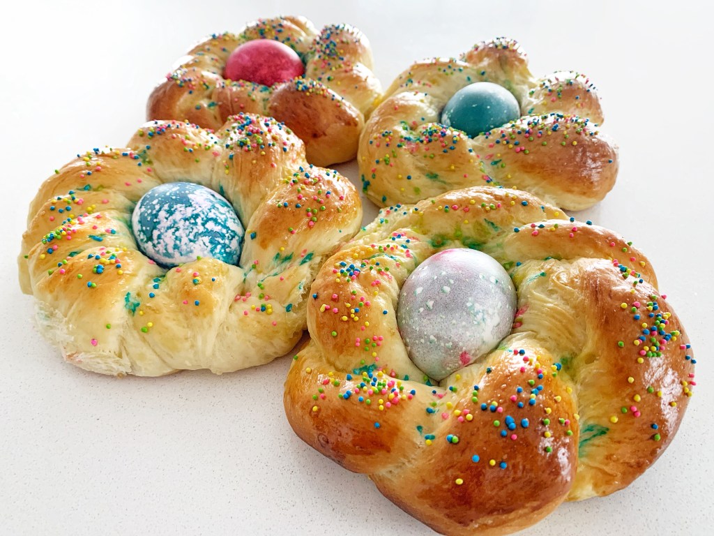 Freshly baked pane di Pasqua Italian Easter bread with colorful eggs and sugar sprinkles
