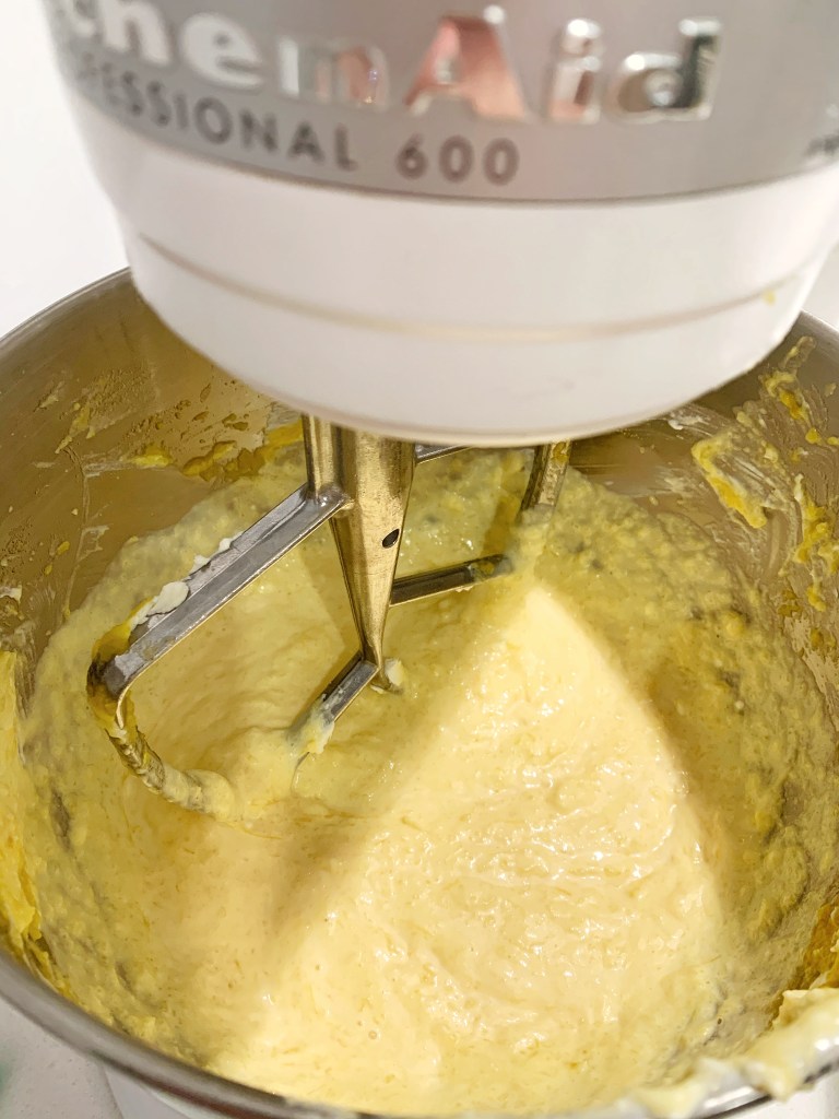 Pumpkin pie filling being mixed in a stand mixer until smooth and creamy.