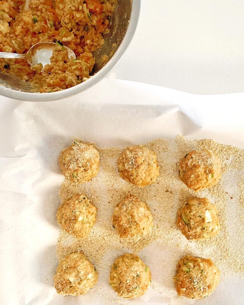Shaping veggie balls and coating them with breadcrumbs before baking
