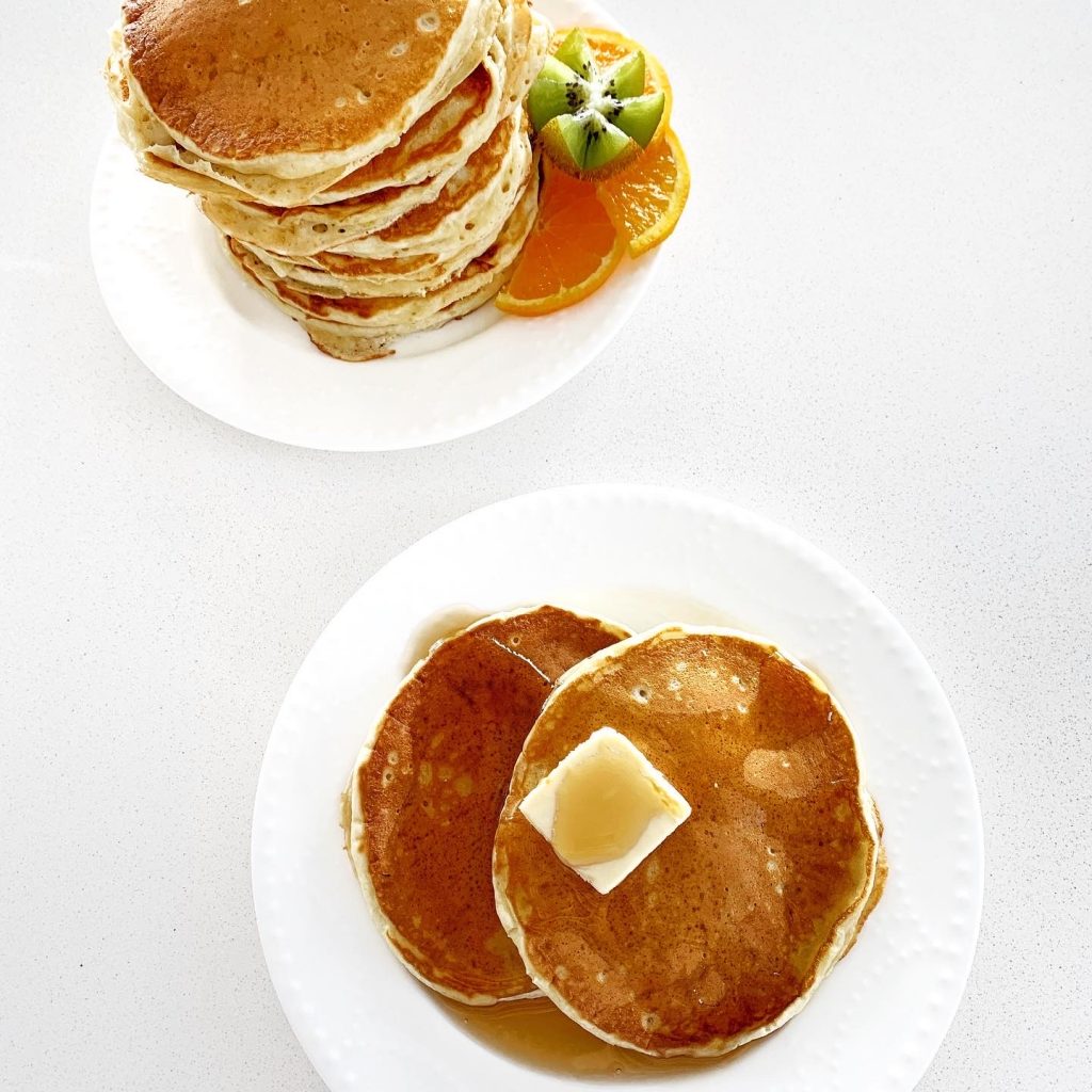Fluffy homemade weekend pancakes stacked with maple syrup.