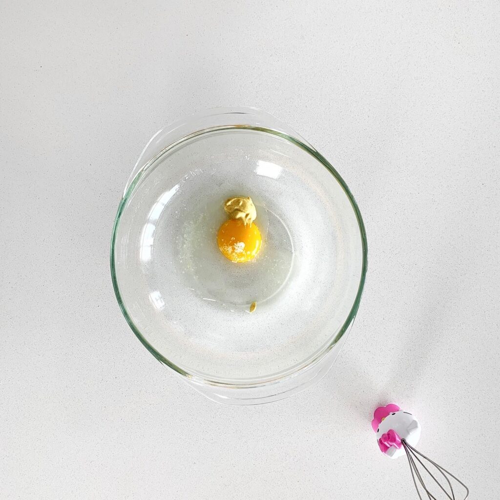Egg yolk in a small bowl as the base for making homemade truffle aioli.