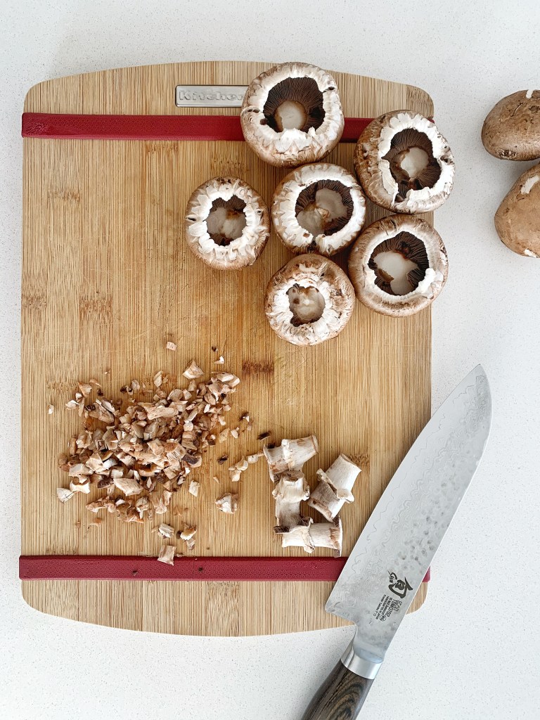 Chopping mushroom stems for stuffed mushrooms with rosemary and brie